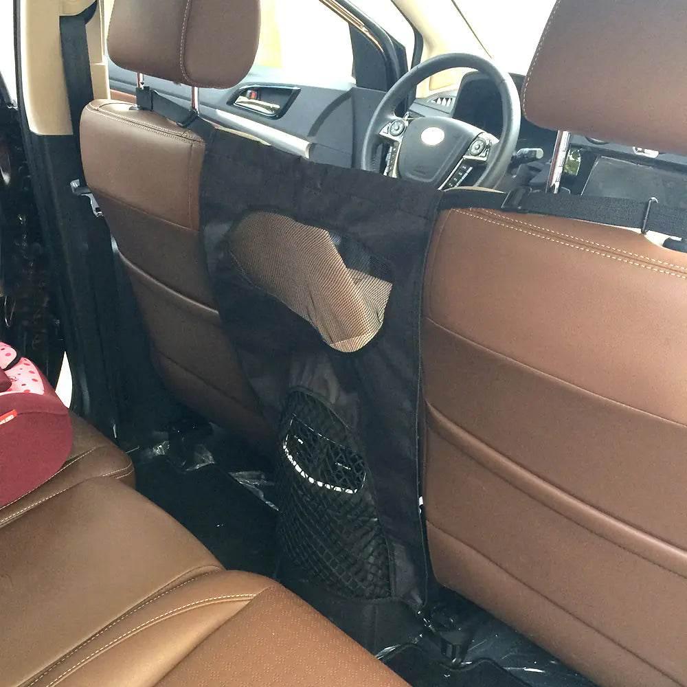 Black pet car seat barrier with mesh pockets, installed between front and back seats for dog safety during travel