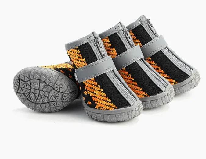 Dog boots with orange and black pattern, gray soles, and zipper closure for pet paw protection