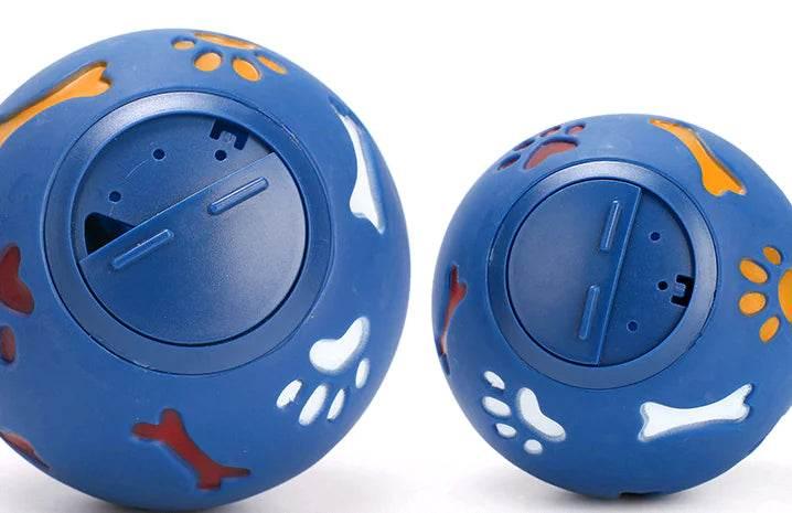 Blue dog treat dispensing balls with paw and bone cutouts for interactive pet play