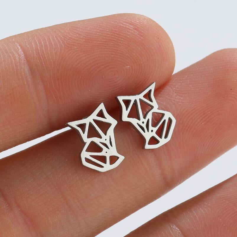 Geometric cat-shaped stud earrings held on fingertips, silver tone, minimalist pet-themed jewelry