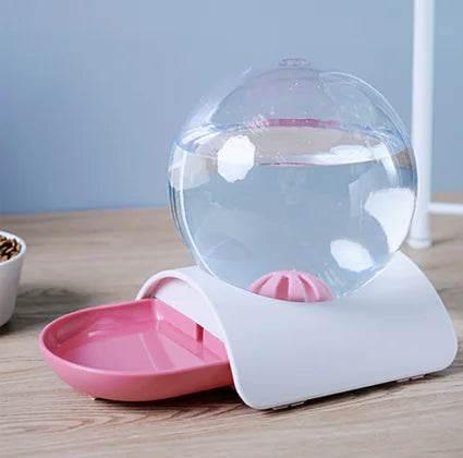 Automatic pet water dispenser with pink bowl and clear spherical reservoir for cats and dogs