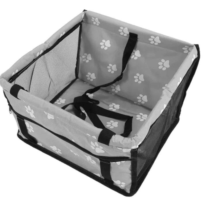 Gray pet carrier with white paw prints, mesh sides, and black handles for dogs or cats