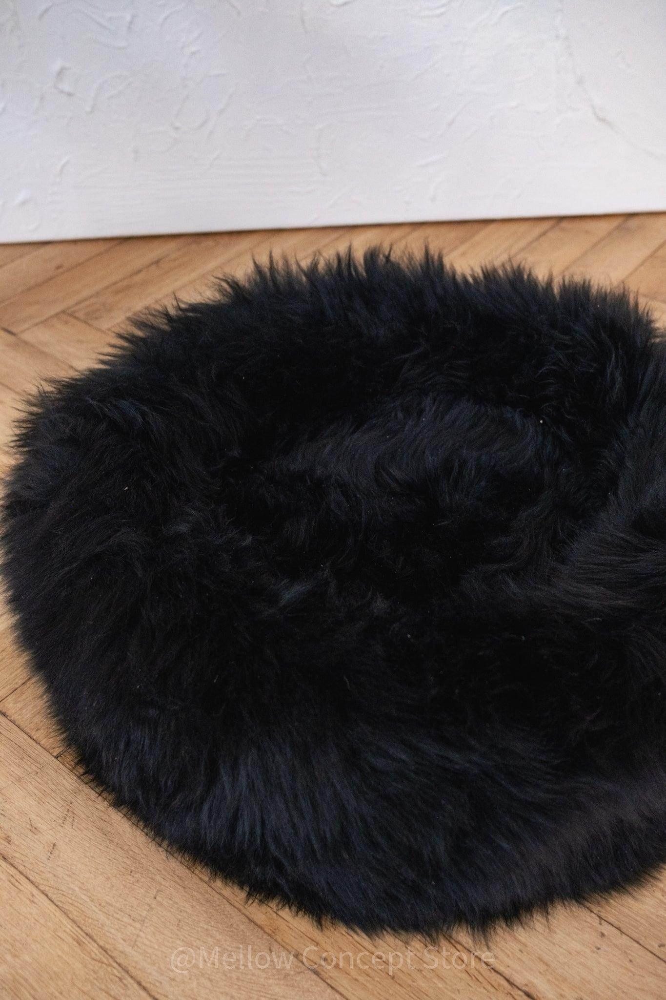 Soft black faux fur pet bed on wooden floor, cozy pet accessory for dogs and cats