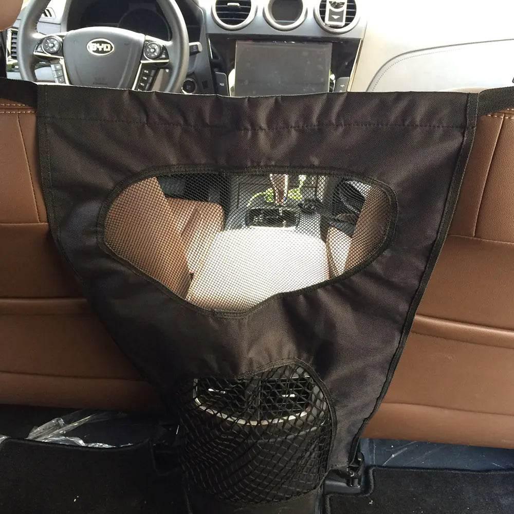 Black pet car barrier with mesh window and storage pocket, installed between front and back seats for dog safety