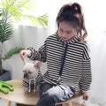 Woman and French bulldog in matching striped hoodies, cozy pet fashion for dogs and owners