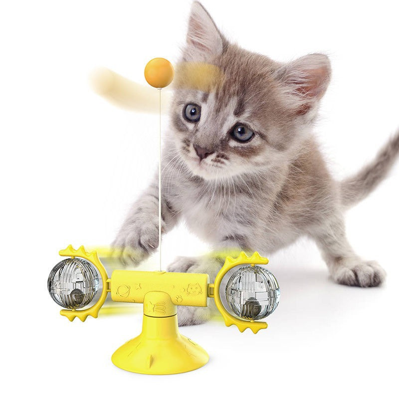 Adorable gray kitten playing with yellow interactive cat toy featuring spinning balls and dangling ball.